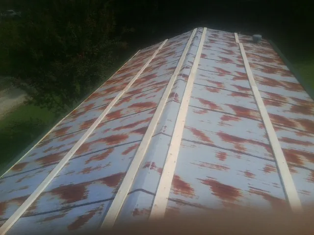 Rusted metal roof panels with new wood purlins before replacement — Storm Damage Roof Repair in Pauls Valley by Roofing Brothers