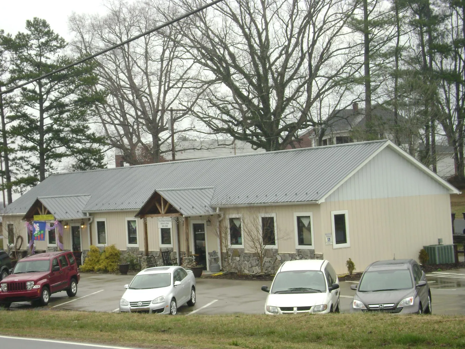 Gray metal roof with timber entry brackets on a small commercial building in Pauls Valley