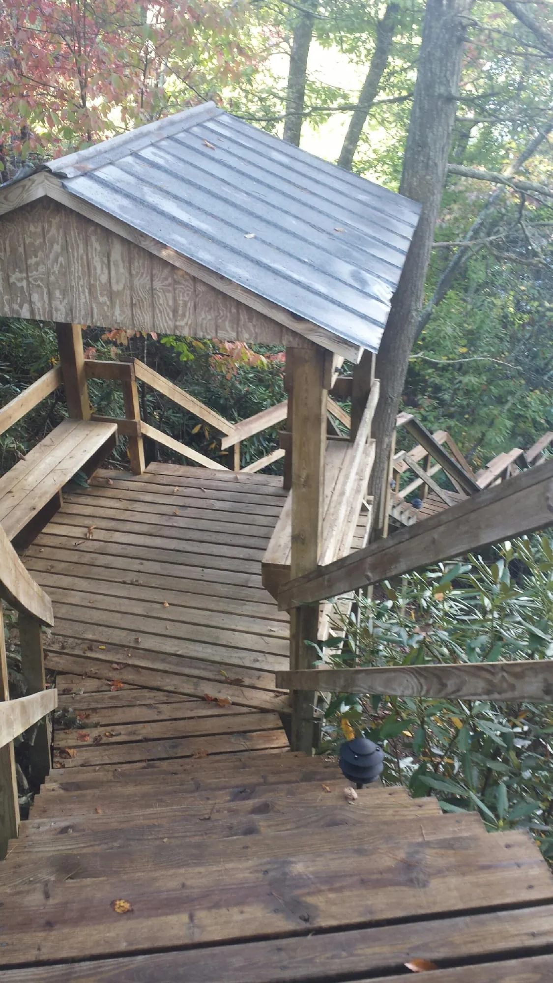 Metal roofed shelter over wooden steps on a wooded walkway — Skylight Repair & Installation work by our crew in Pauls Valley