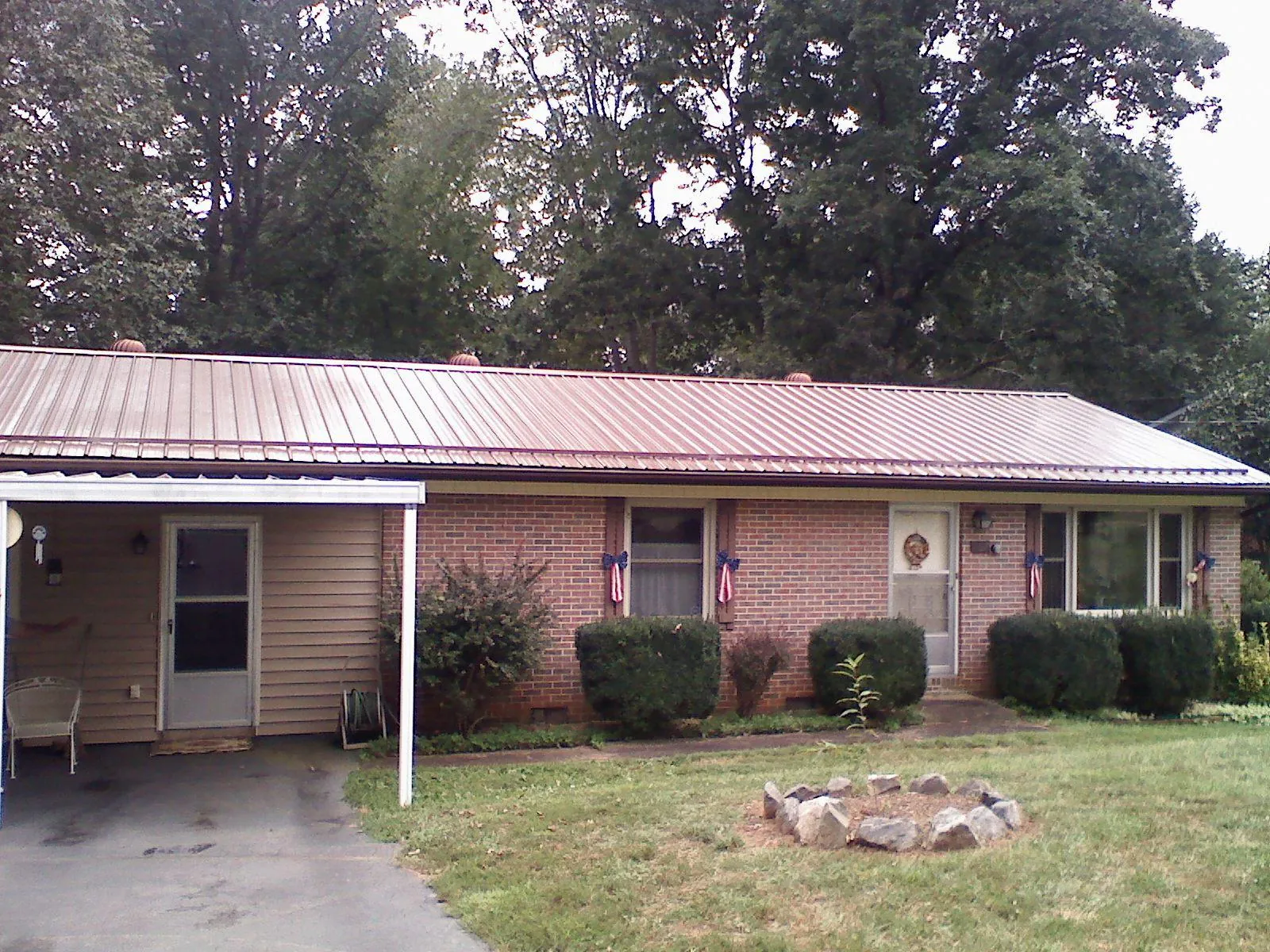 Bronze metal roof and carport on a brick ranch home — Roof Repair work by our crew in Pauls Valley